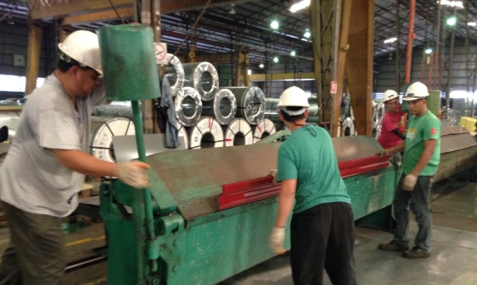 People operating on coil bending machine